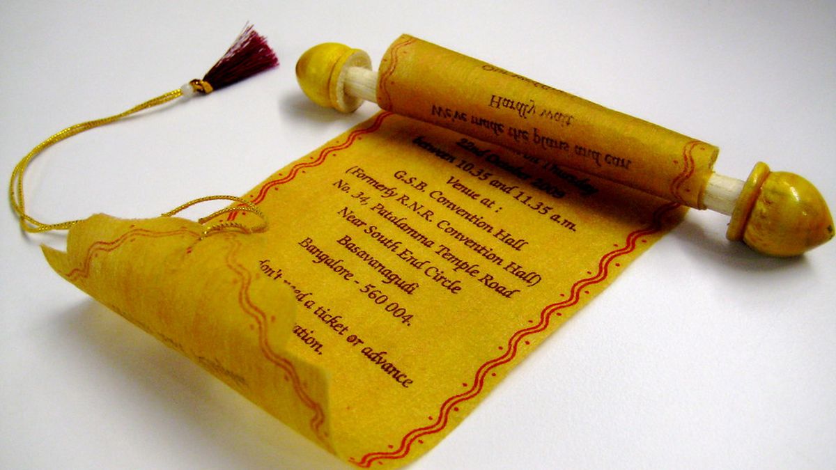 A yellow scroll-style wedding invitation