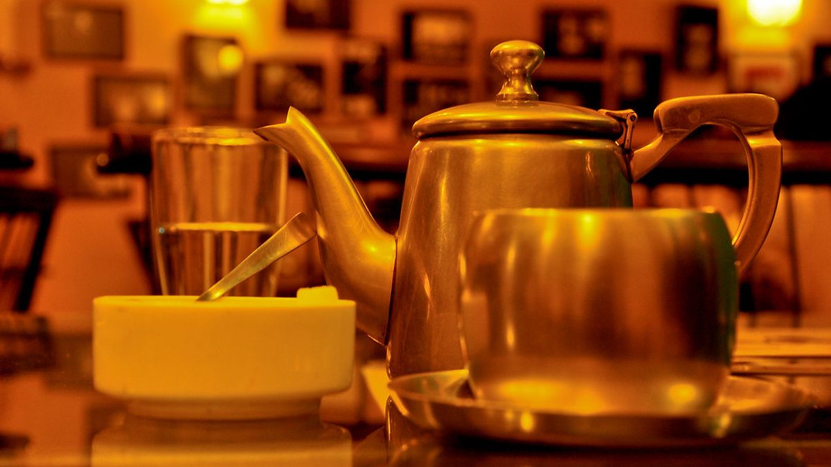 A brass teapot and cups of masala chai